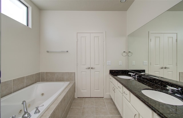 bathroom featuring vanity, a relaxing tiled tub, and tile patterned floors