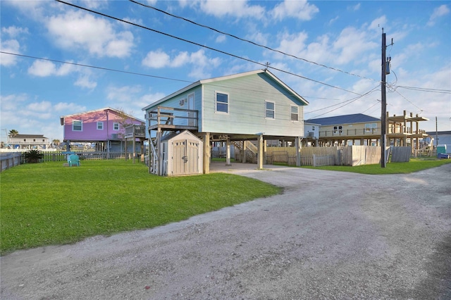 view of front facade featuring a carport, a storage shed, and a front yard