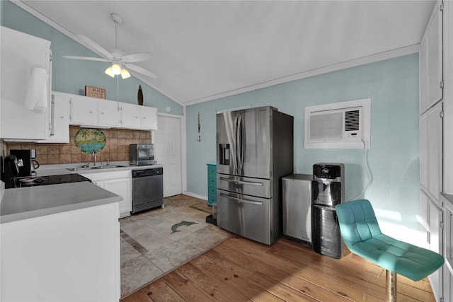 kitchen featuring appliances with stainless steel finishes, vaulted ceiling, ceiling fan, light hardwood / wood-style floors, and white cabinetry