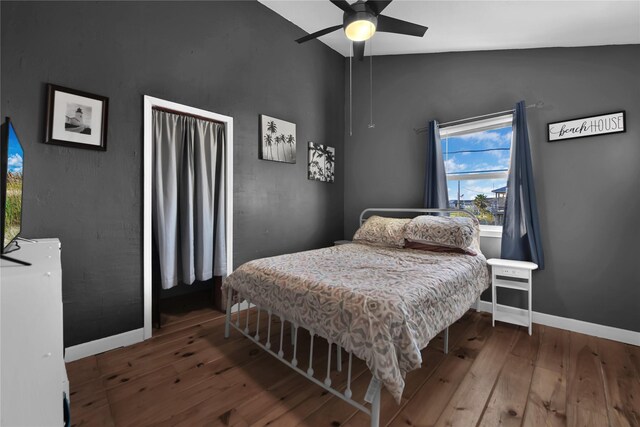 bedroom with ceiling fan, vaulted ceiling, and hardwood / wood-style flooring