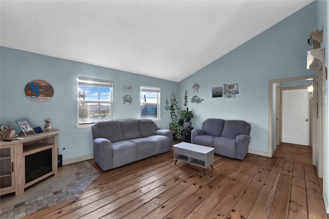 living room with light wood-type flooring and high vaulted ceiling