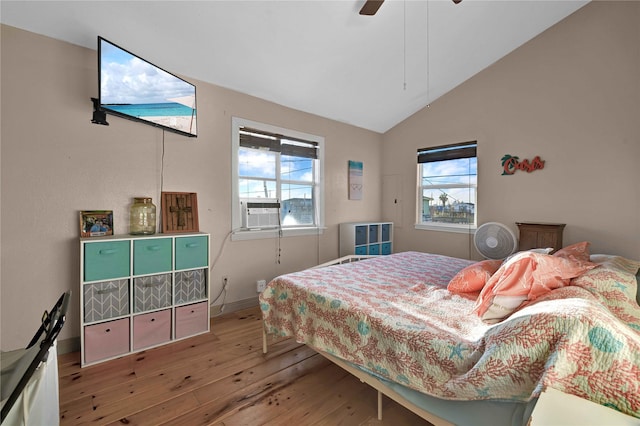 bedroom featuring hardwood / wood-style floors, vaulted ceiling, multiple windows, and ceiling fan