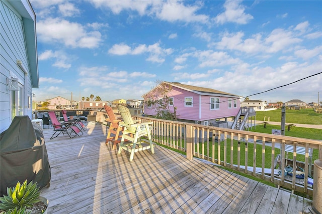 wooden terrace featuring grilling area and a yard