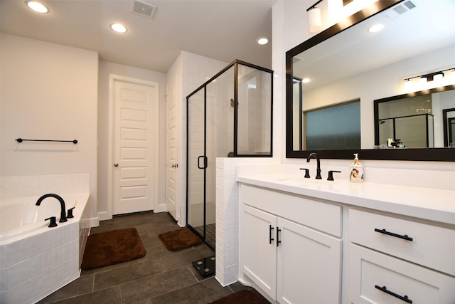 bathroom featuring tile patterned flooring, shower with separate bathtub, and vanity