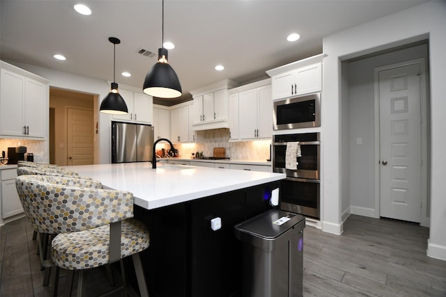 kitchen featuring backsplash, white cabinets, and stainless steel appliances