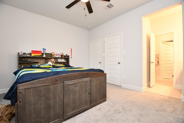 bedroom featuring light carpet, ensuite bath, and ceiling fan