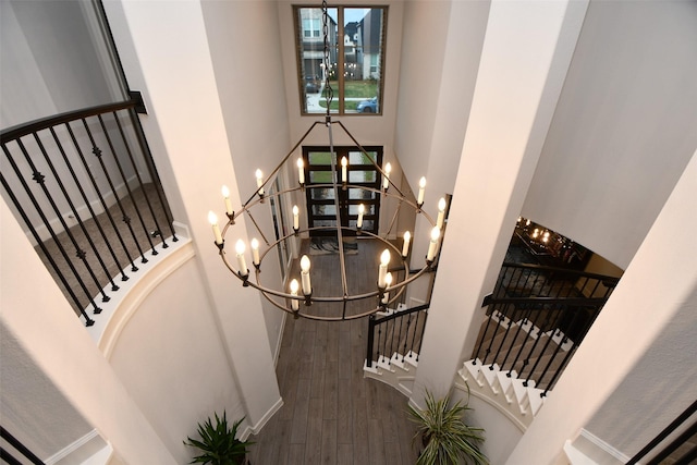 staircase featuring hardwood / wood-style flooring and an inviting chandelier