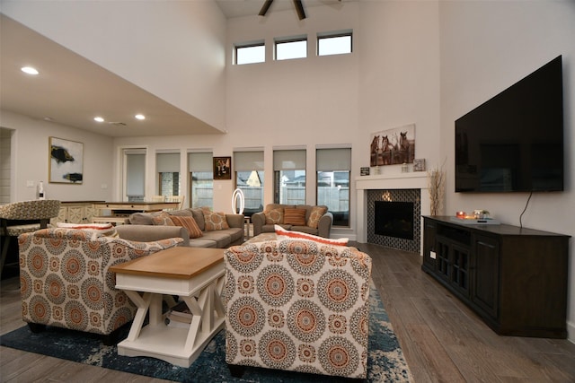 living room featuring a fireplace, a high ceiling, and dark hardwood / wood-style flooring