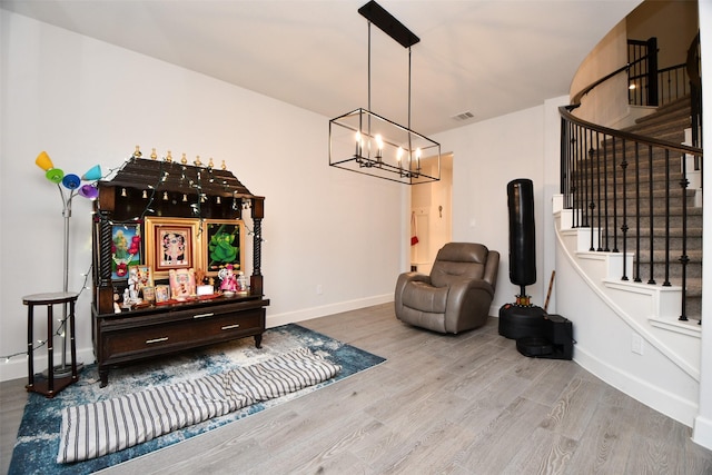 living area with wood-type flooring and a notable chandelier