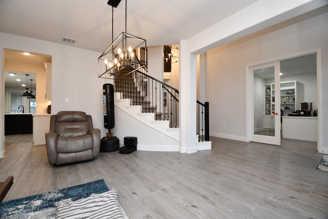 interior space with a chandelier, sink, and wood-type flooring