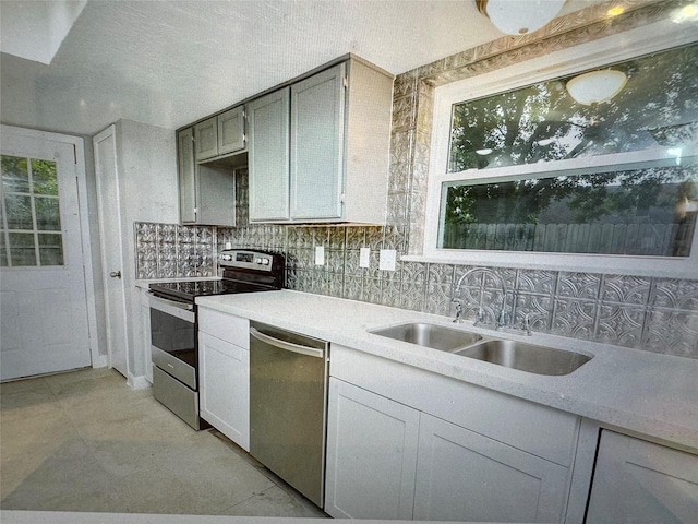 kitchen with backsplash, gray cabinets, sink, and stainless steel appliances