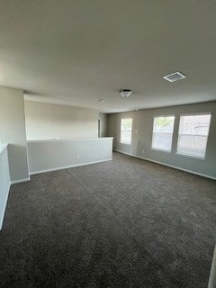 unfurnished room with dark carpet