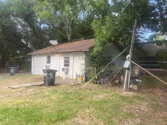 rear view of property featuring cooling unit and a yard