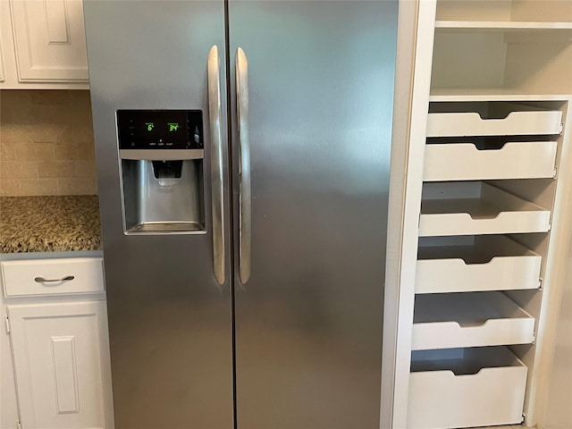 kitchen with backsplash, stainless steel fridge with ice dispenser, white cabinets, and dark stone counters