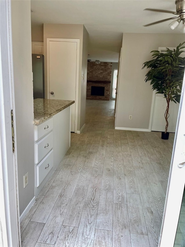 kitchen featuring stainless steel refrigerator, ceiling fan, white cabinets, and light hardwood / wood-style floors