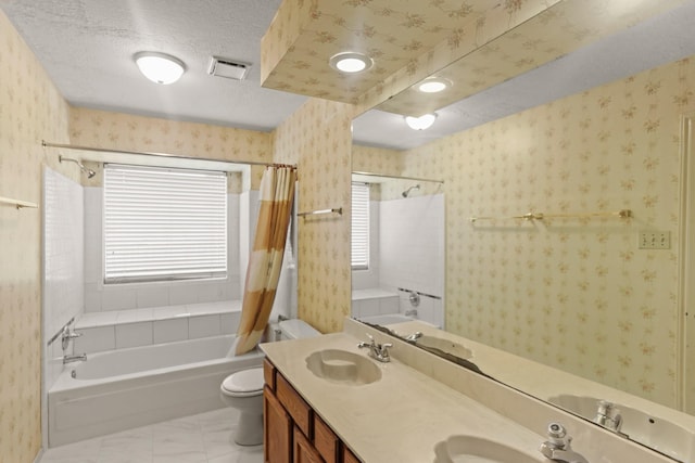 bathroom with a textured ceiling, vanity, and toilet