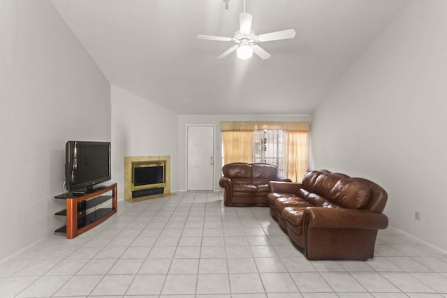 living room with ceiling fan, lofted ceiling, light tile patterned floors, and a tiled fireplace