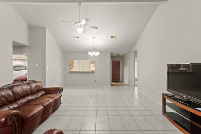 tiled living room featuring ceiling fan with notable chandelier and high vaulted ceiling