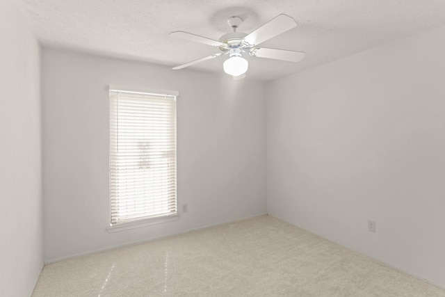 unfurnished room with light carpet, a textured ceiling, a wealth of natural light, and ceiling fan