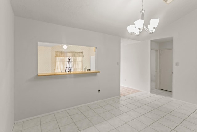 spare room featuring a chandelier and light tile patterned floors