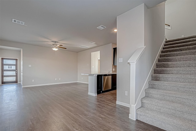 unfurnished living room with hardwood / wood-style floors, ceiling fan, and sink