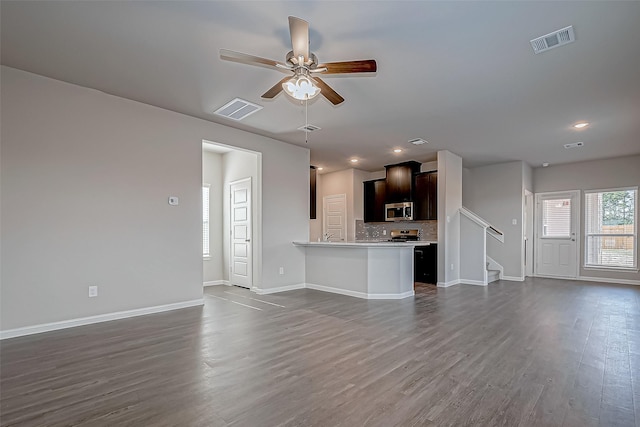 unfurnished living room with ceiling fan and dark wood-type flooring