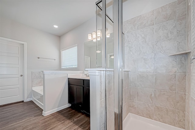 bathroom featuring vanity, wood-type flooring, a notable chandelier, and shower with separate bathtub