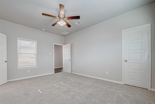 carpeted spare room featuring ceiling fan