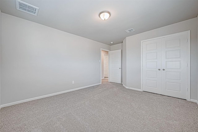 unfurnished bedroom featuring light carpet and a closet