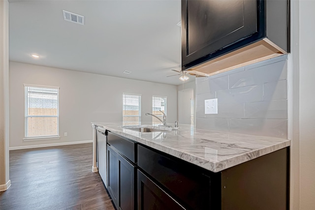 kitchen with ceiling fan, a healthy amount of sunlight, dark wood-type flooring, and a kitchen island with sink