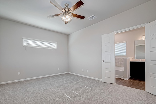 unfurnished bedroom featuring carpet floors, ensuite bathroom, and ceiling fan