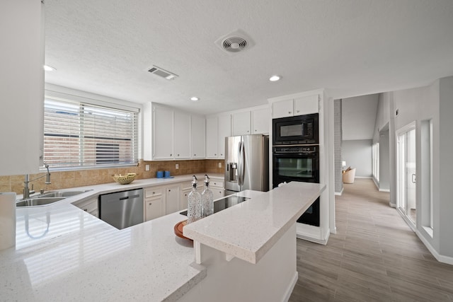 kitchen featuring white cabinets, a textured ceiling, sink, and black appliances