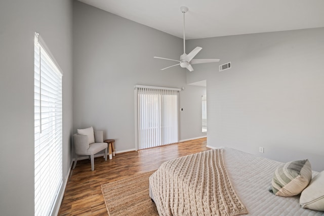 bedroom with ceiling fan, dark wood-type flooring, and high vaulted ceiling