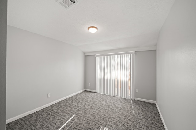 carpeted empty room featuring vaulted ceiling