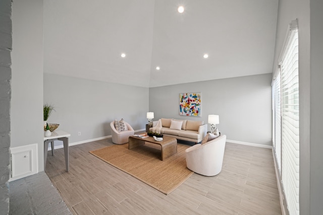 living room featuring high vaulted ceiling, recessed lighting, light wood-style flooring, and baseboards