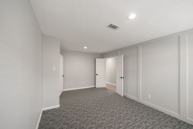 unfurnished room featuring dark carpet