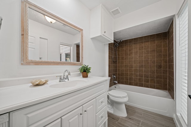 full bathroom with vanity, toilet, and tiled shower / bath