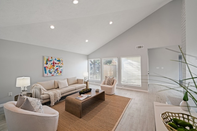 living room featuring light hardwood / wood-style flooring and high vaulted ceiling