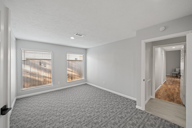 spare room with hardwood / wood-style floors and a textured ceiling