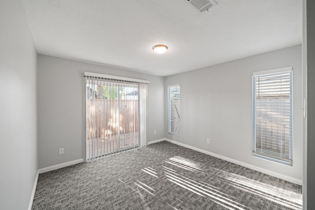 carpeted spare room featuring a textured ceiling