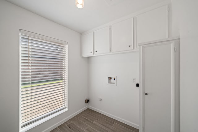 clothes washing area featuring dark hardwood / wood-style flooring, cabinets, and washer hookup