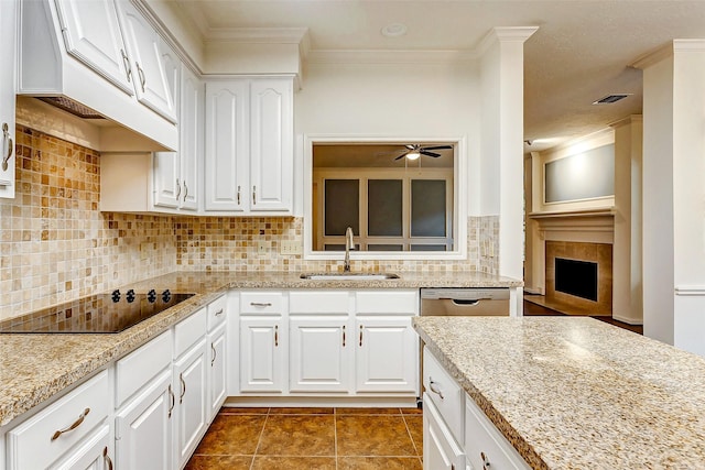 kitchen featuring decorative backsplash, sink, white cabinets, and black electric stovetop