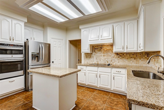 kitchen featuring sink, stainless steel appliances, a kitchen island, and light stone countertops