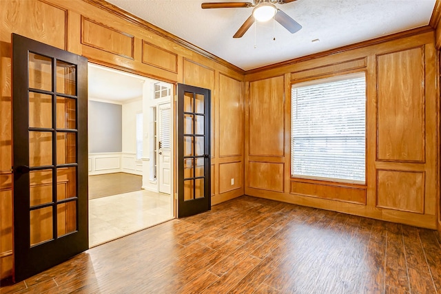 spare room featuring ornamental molding, hardwood / wood-style flooring, ceiling fan, and french doors