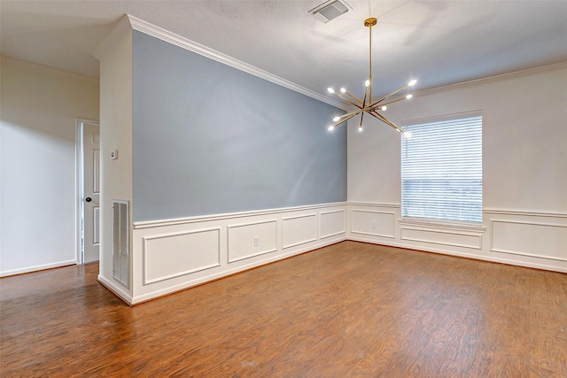 empty room featuring ornamental molding, hardwood / wood-style flooring, and an inviting chandelier