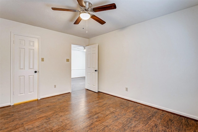 spare room featuring dark wood-type flooring and ceiling fan