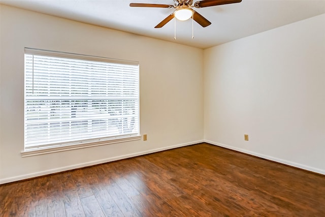 empty room with ceiling fan, plenty of natural light, and dark hardwood / wood-style flooring