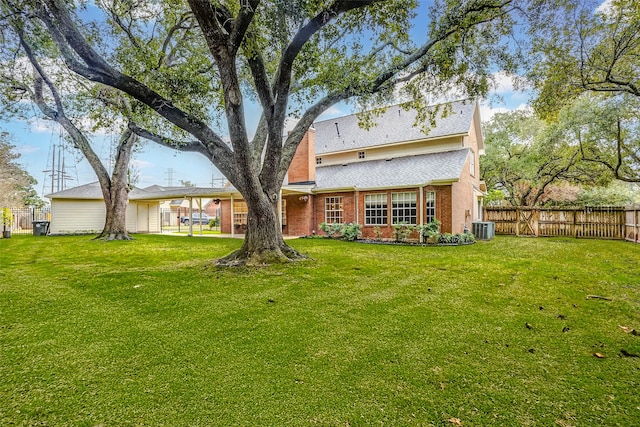 back of property with central air condition unit and a lawn