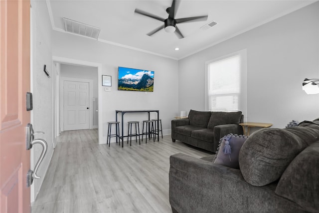 living room with light hardwood / wood-style floors, ceiling fan, and crown molding