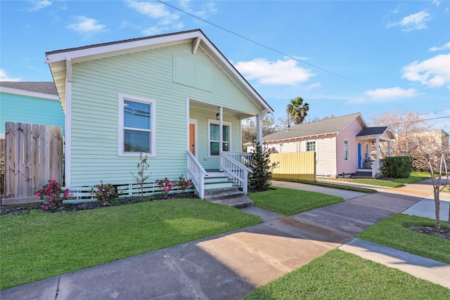 bungalow-style home with a front lawn and covered porch